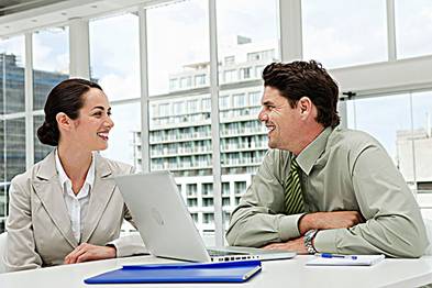 Businessman and businesswoman meeting in office with laptop